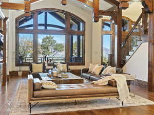 Living room with hardwood / wood-style flooring, beamed ceiling, and high vaulted ceiling