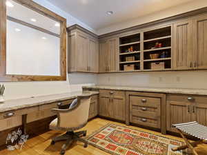 Office with light hardwood / wood-style flooring and built in desk