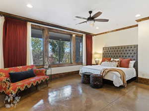 Bedroom with ceiling fan, concrete flooring, and ornamental molding