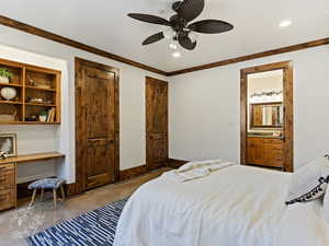 Bedroom with ceiling fan, ensuite bathroom, and ornamental molding