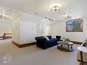 Living room with light carpet and vaulted ceiling