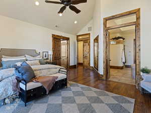 Bedroom with dark hardwood / wood-style floors, ceiling fan, high vaulted ceiling, and a closet