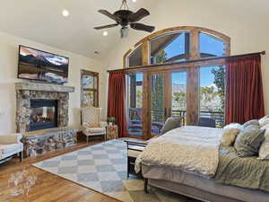 Bedroom with ceiling fan, wood-type flooring, a fireplace, and multiple windows