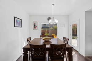 Dining space featuring dark hardwood / wood-style floors and an inviting chandelier