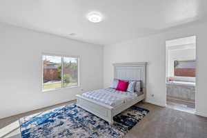 Bedroom with ensuite bath, carpet floors, and a textured ceiling