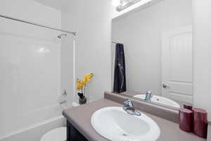 Full bathroom with vanity, toilet, and shower / bathtub combination with curtain