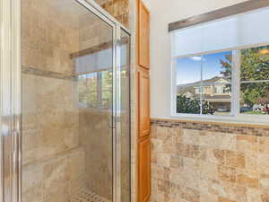 Bathroom with an enclosed shower and tile walls