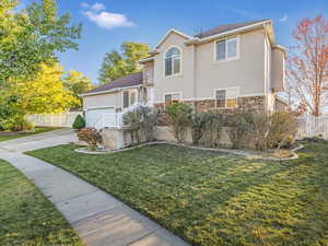 View of property featuring a front yard and a garage