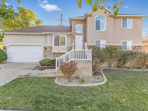 View of front of home with a garage and a front yard