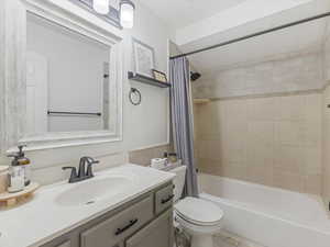 Full bathroom with shower / bath combination with curtain, vanity, and toilet