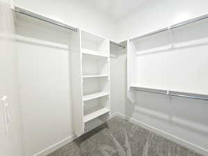 Walk in closet with dark colored carpet