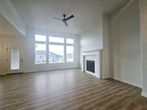 Unfurnished living room featuring a fireplace, ceiling fan, and hardwood / wood-style floors