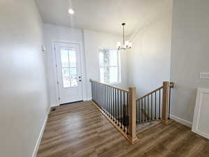 Entryway featuring wood-type flooring and a notable chandelier