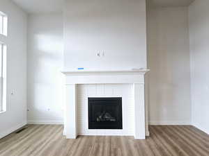 Details with hardwood / wood-style floors and a tiled fireplace