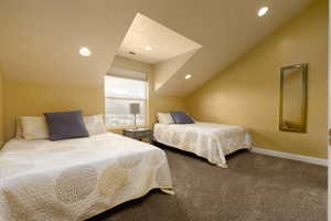 Bedroom featuring carpet flooring and lofted ceiling