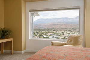 Bedroom featuring a mountain view, carpet floors, and multiple windows