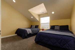 Bedroom featuring carpet, a textured ceiling, and lofted ceiling