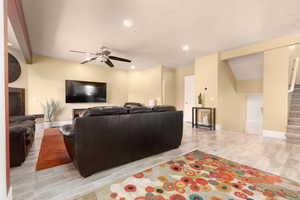 Living room with light wood-type flooring and ceiling fan