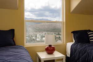 Bedroom featuring a mountain view and multiple windows