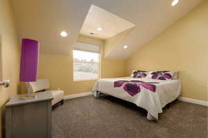 Carpeted bedroom with lofted ceiling