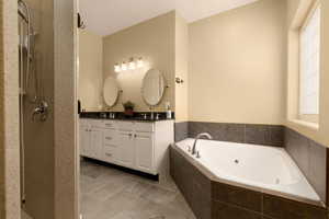 Bathroom with plus walk in shower, tile patterned flooring, and vanity