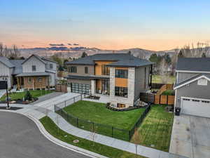 View of front of property featuring a mountain view, a yard, and a garage