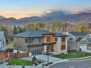 View of front of home featuring a lawn, a mountain view, and a garage