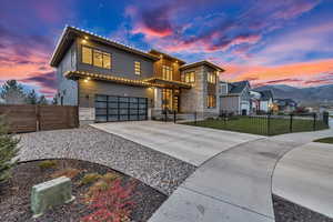 View of front facade featuring a lawn, a mountain view, and a garage