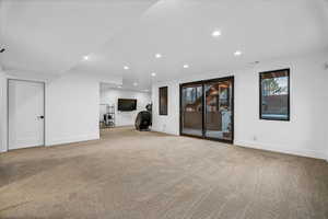 Unfurnished living room featuring light carpet