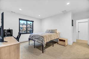 Bedroom featuring light carpet