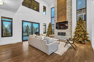 Living room with a fireplace, hardwood / wood-style floors, and a towering ceiling