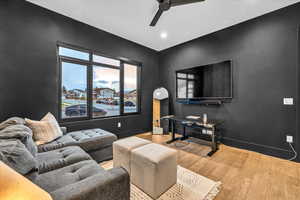 Living room with light wood-type flooring and ceiling fan