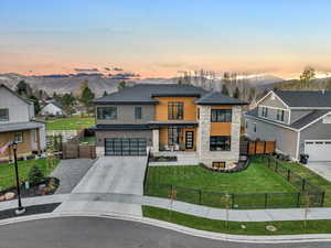 View of front of house featuring a mountain view, a garage, and a yard