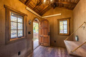 Entrance foyer with wooden ceiling, dark wood-type flooring, and a wealth of natural light