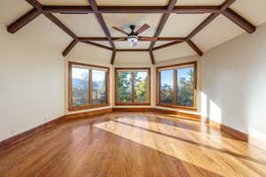 Interior space with ceiling fan, light wood-type flooring, and lofted ceiling