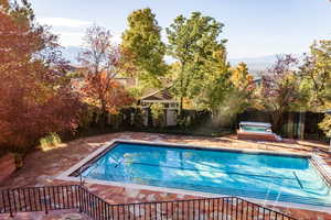 View of pool with a mountain view, a patio area, and a hot tub