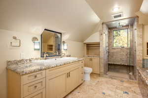 Bathroom featuring a shower with door, vanity, lofted ceiling, and toilet