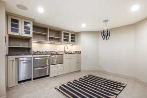 Kitchen with sink, light tile patterned floors, hanging light fixtures, and cream cabinetry