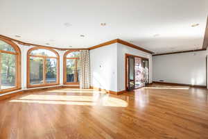 Empty room featuring light hardwood / wood-style floors and crown molding