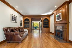 Living room featuring ornamental molding and light hardwood / wood-style flooring