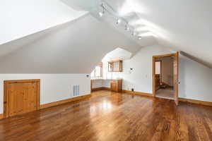 Bonus room featuring hardwood / wood-style flooring and vaulted ceiling