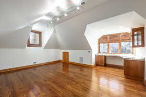 Bonus room with light hardwood / wood-style floors and lofted ceiling