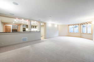 Unfurnished living room with light colored carpet