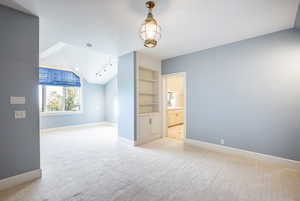 Interior space with light colored carpet and vaulted ceiling