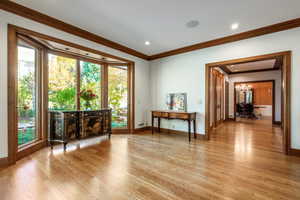 Interior space featuring crown molding, light hardwood / wood-style flooring, and a chandelier