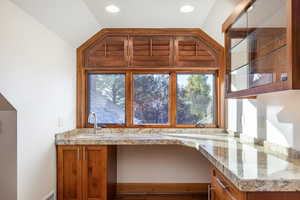 Kitchen with a wealth of natural light, sink, and vaulted ceiling