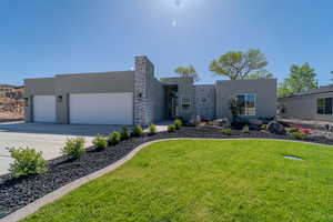 View of front of house featuring a garage and a front yard