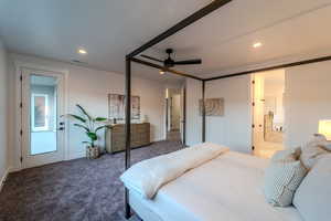 Bedroom featuring connected bathroom, ceiling fan, and dark colored carpet