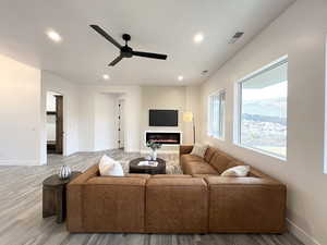 Living room with ceiling fan and hardwood / wood-style floors