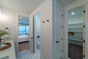 Hallway featuring light colored carpet and sink